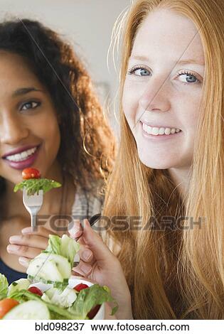 Stock Photo - Friends eating salad together. Fotosearch