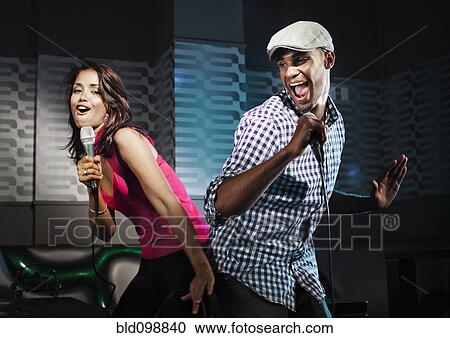 Friends singing karaoke in nightclub View Large Photo Image Stock Image - Friends singing karaoke in nightclub. Fotosearch