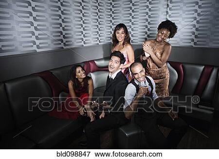 Stock Photo - Friends singing karaoke in nightclub. Fotosearch