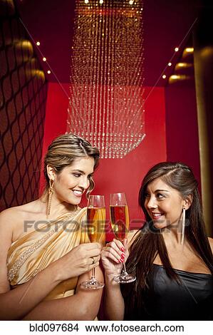 Picture - Glamorous Hispanic women toasting with Champagne. Fotosearch