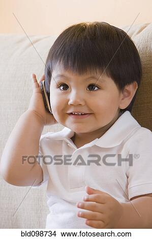 Picture - Hispanic baby boy using cell phone. Fotosearch