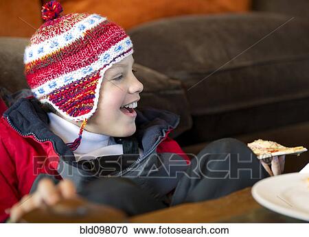 Stock Image - Hispanic boy eating pizza. Fotosearch