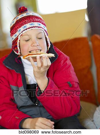 Stock Photo - Hispanic boy eating pizza. Fotosearch