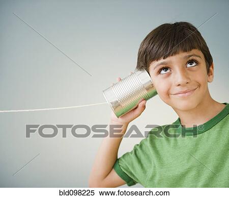 Hispanic boy listening to tin can telephone View Large Photo Image Stock Photography - Hispanic boy listening to tin can telephone. Fotosearch
