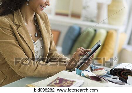 Stock Image - Hispanic businesswoman using digital tablet. Fotosearch