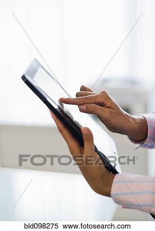 Stock Photography - Hispanic businesswoman using digital tablet in office. Fotosearch