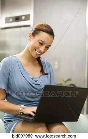 Stock Photo - Hispanic businesswoman using laptop. Fotosearch