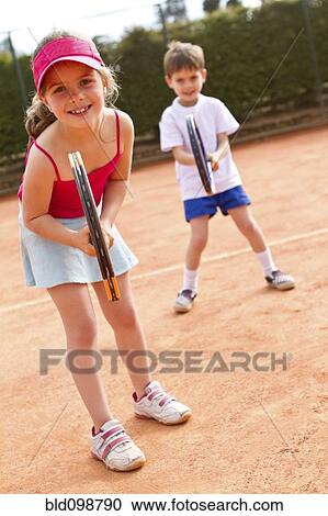 Hispanic children playing double's tennis View Large Photo Image Stock Image - Hispanic children playing double's tennis. Fotosearch