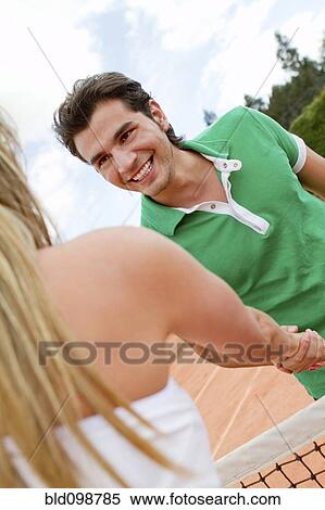 Hispanic couple shaking hands over tennis court net View Large Photo Image Stock Photography - Hispanic couple shaking hands over tennis court net. Fotosearch