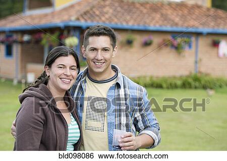 Stock Photograph - Hispanic couple standing outdoors together. Fotosearch