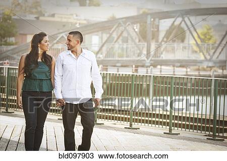 Hispanic couple walking on urban bridge View Large Photo Image Stock Image - Hispanic couple walking on urban bridge. Fotosearch