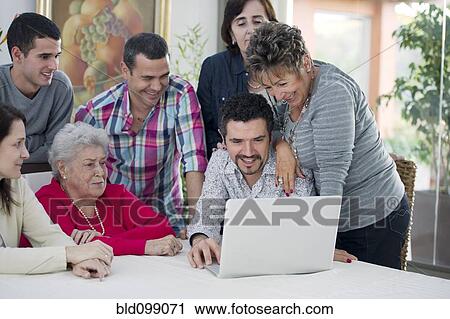 Hispanic family looking at laptop View Large Photo Image Stock Image - Hispanic family looking at laptop. Fotosearch