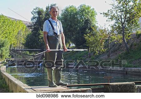 Stock Photograph - Hispanic fisherman holding net. Fotosearch