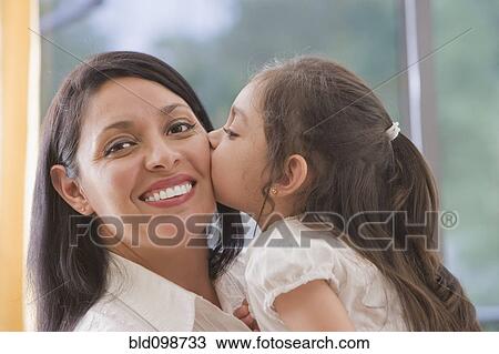 Hispanic girl kissing mother's cheek View Large Photo Image Stock Image - Hispanic girl kissing mother's cheek. Fotosearch