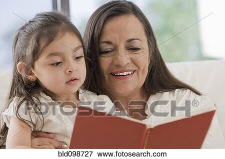 Hispanic grandmother reading to granddaughter View Large Photo Image Stock Photo - Hispanic grandmother reading to granddaughter. Fotosearch