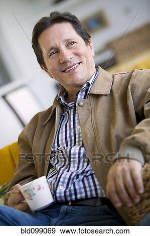 Stock Photo - Hispanic man drinking coffee. Fotosearch