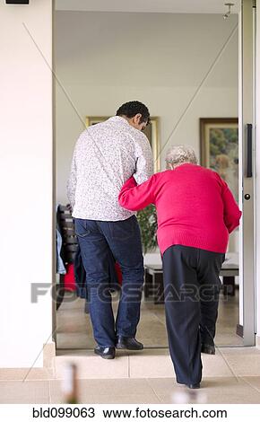 Hispanic man helping his grandmother to walk View Large Photo Image Stock Image - Hispanic man helping his grandmother to walk. Fotosearch
