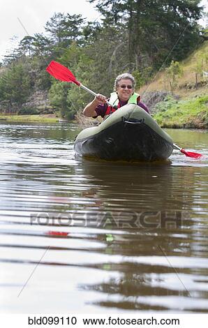 Stock Image - Hispanic man in kayak on river. Fotosearch