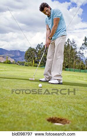 Hispanic man putting golf ball View Large Photo Image Stock Photo - Hispanic man putting golf ball. Fotosearch