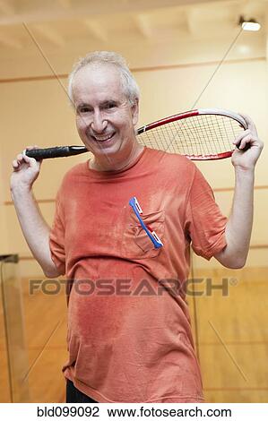 Stock Image - Hispanic man relaxing after racquetball. Fotosearch