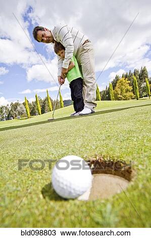 Hispanic man teaching boy to play golf View Large Photo Image Stock Image - Hispanic man teaching boy to play golf. Fotosearch