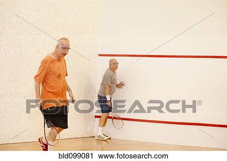 Stock Image - Hispanic men playing racquetball. Fotosearch