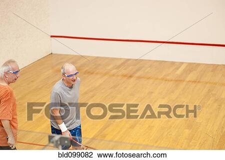 Stock Image - Hispanic men playing racquetball. Fotosearch