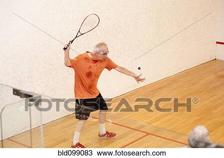 Stock Image - Hispanic men playing racquetball. Fotosearch