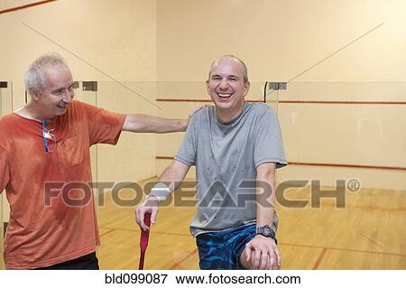 Stock Photo - Hispanic men relaxing after racquetball. Fotosearch