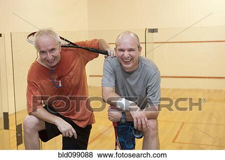 Stock Photo - Hispanic men relaxing after racquetball. Fotosearch