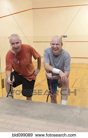 Stock Photo - Hispanic men relaxing after racquetball. Fotosearch