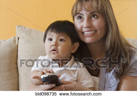 Stock Photography - Hispanic mother and son watching television. Fotosearch
