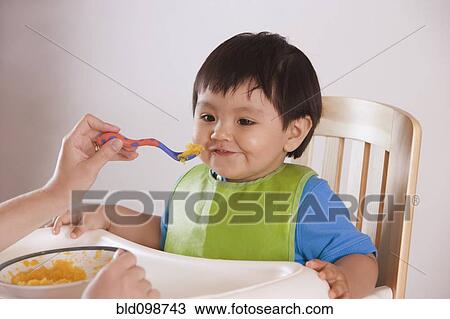 Hispanic mother feeding baby boy View Large Photo Image Stock Image - Hispanic mother feeding baby boy. Fotosearch