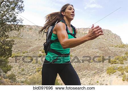 Stock Photograph - Hispanic runner training in remote area. Fotosearch