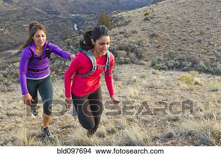 Picture - Hispanic runners training in remote area. Fotosearch