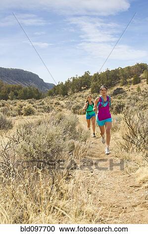 Stock Image - Hispanic runners training in remote area. Fotosearch