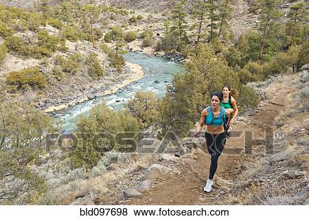 Stock Photo - Hispanic runners training in remote area. Fotosearch