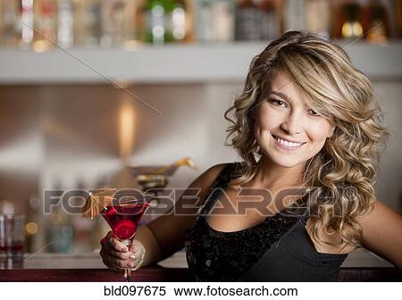 Stock Photography - Hispanic woman drinking martini. Fotosearch