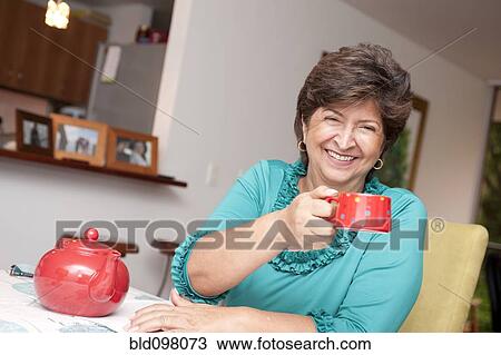 Stock Image - Hispanic woman drinking tea. Fotosearch