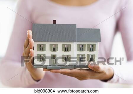 Hispanic woman holding miniature house View Large Photo Image Picture - Hispanic woman holding miniature house. Fotosearch