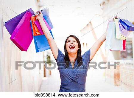 Hispanic woman lifting shopping bags View Large Photo Image Picture - Hispanic woman lifting shopping bags. Fotosearch