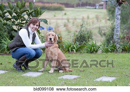 Stock Photo - Hispanic woman petting dog. Fotosearch