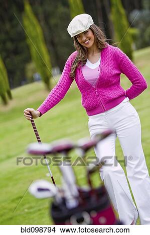 Picture - Hispanic woman playing golf. Fotosearch