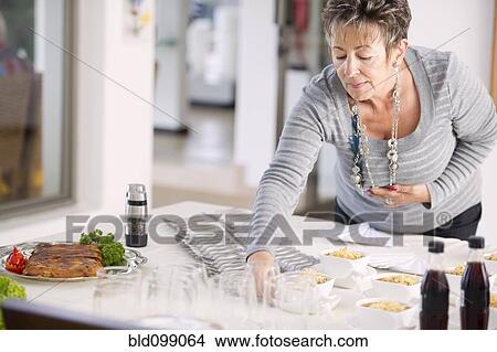 Picture - Hispanic woman preparing for party. Fotosearch