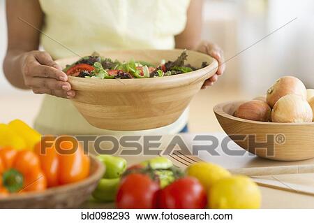 Stock Image - Hispanic woman preparing salad. Fotosearch