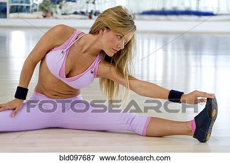 Hispanic woman stretching in health club View Large Photo Image Stock Photo - Hispanic woman stretching in health club. Fotosearch