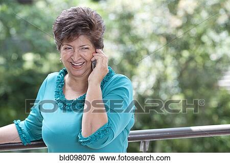 Stock Photograph - Hispanic woman talking on cell phone. Fotosearch