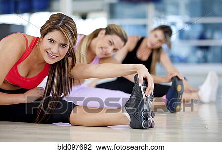 Stock Image - Hispanic women stretching in health club. Fotosearch