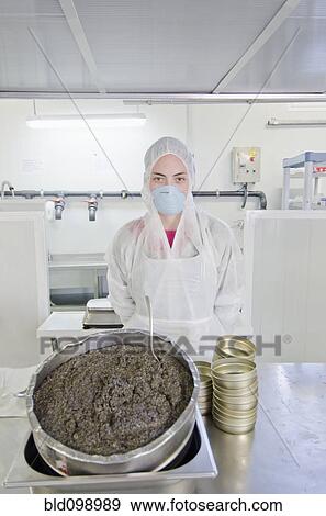 Stock Photo - Hispanic worker filling tins with caviar. Fotosearch