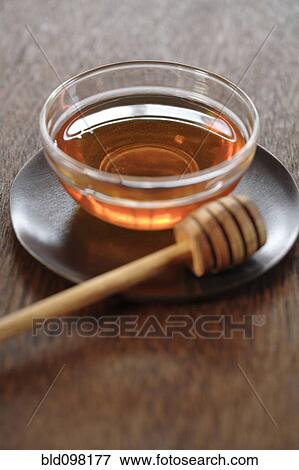 Stock Photo - Honey in bowl with dipper. Fotosearch